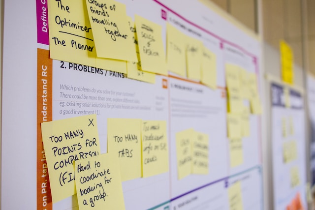 A board displays a series of notes that display users’ feedback and criticisms of a digital product.