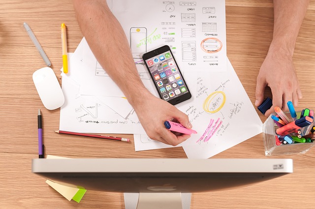 Person brainstorming and highlighting UX design ideas for a mobile application on their phone.
