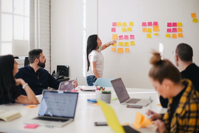 A woman placing sticky notes on the wall.