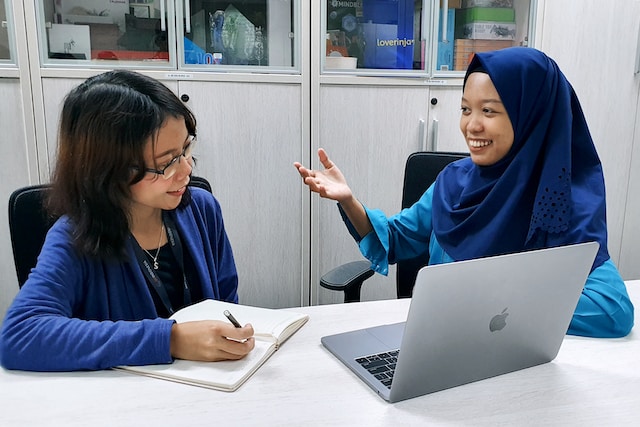 One woman interviewing another woman in a conference room.