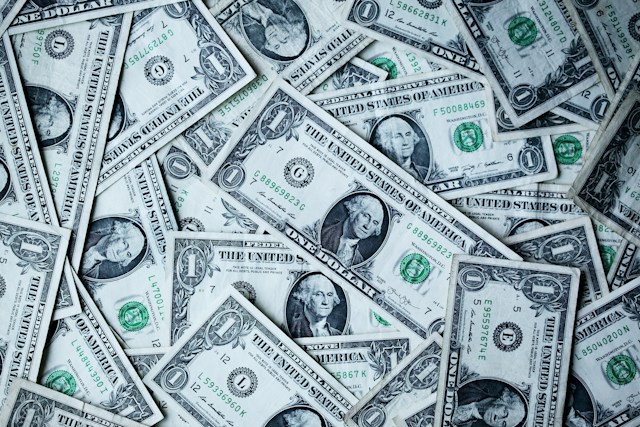 A close-up of a pile of American dollar banknotes. 
