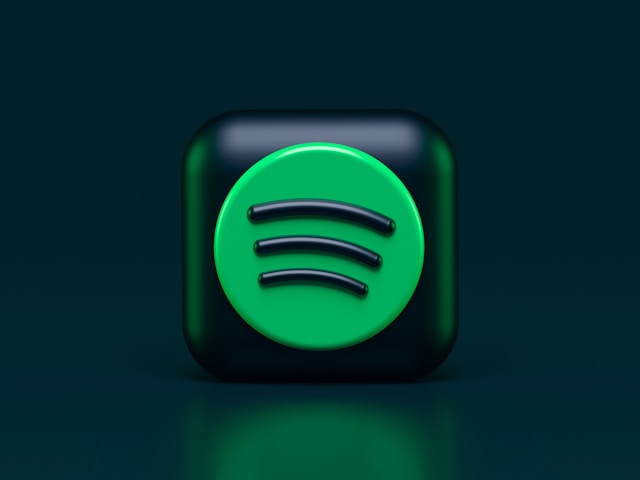 A 3D graphic of the Spotify logo on a dark background with green reflections.
