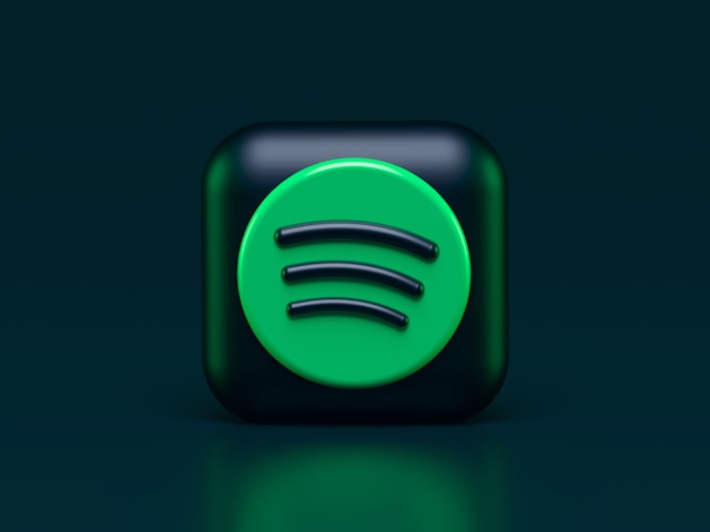 A 3D graphic of the Spotify logo on a dark background with green reflections.