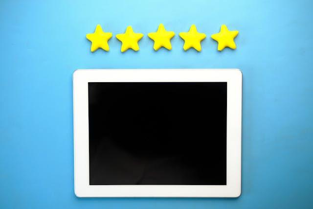 Five bright yellow stars sit above a blackboard on a light blue background.
