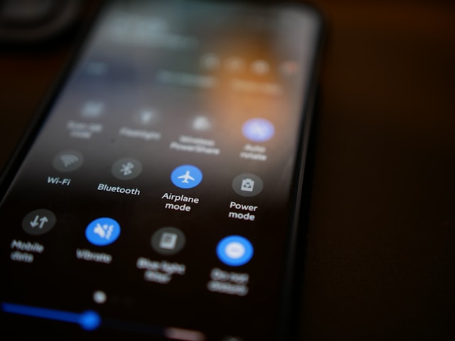 A close-up of a smartphone in dark mode, with Airplane Mode toggled on.