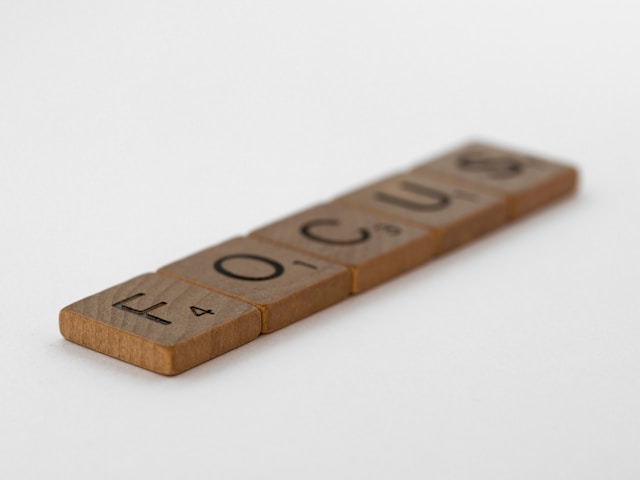 Wooden Scrabble tiles spelling out the word 'FOCUS.'

