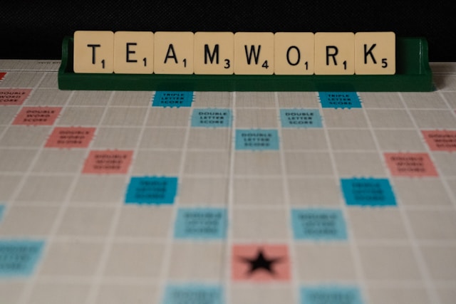 Scrabble tiles spelling out the word “TEAMWORK.”