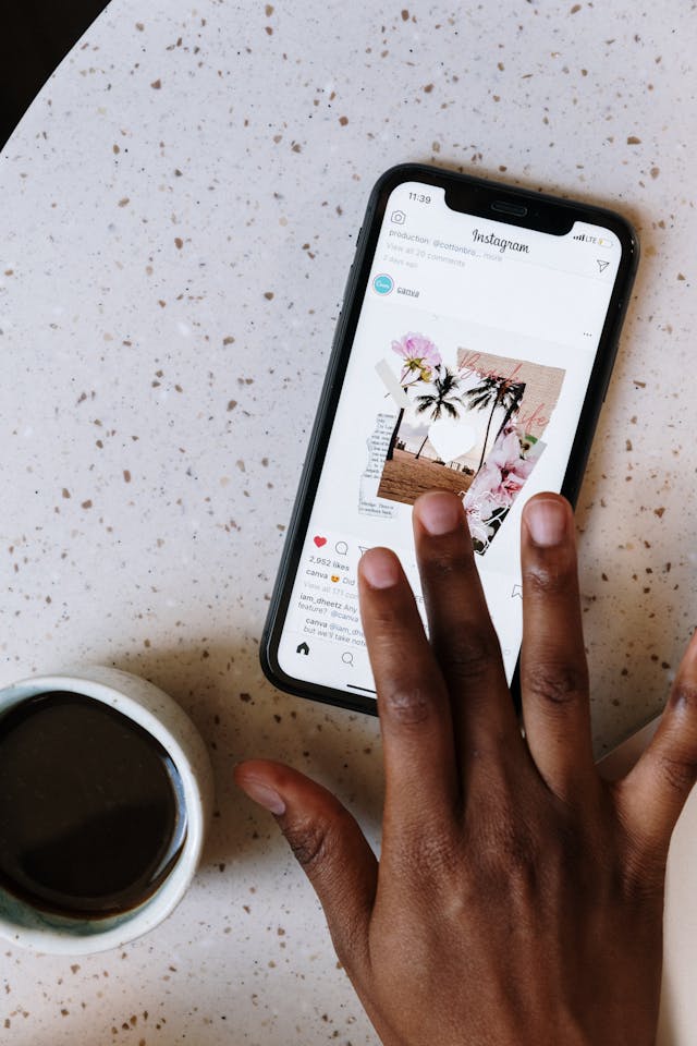 A person likes a photo on Instagram, tapping a visible ‘Like’ button on their phone.