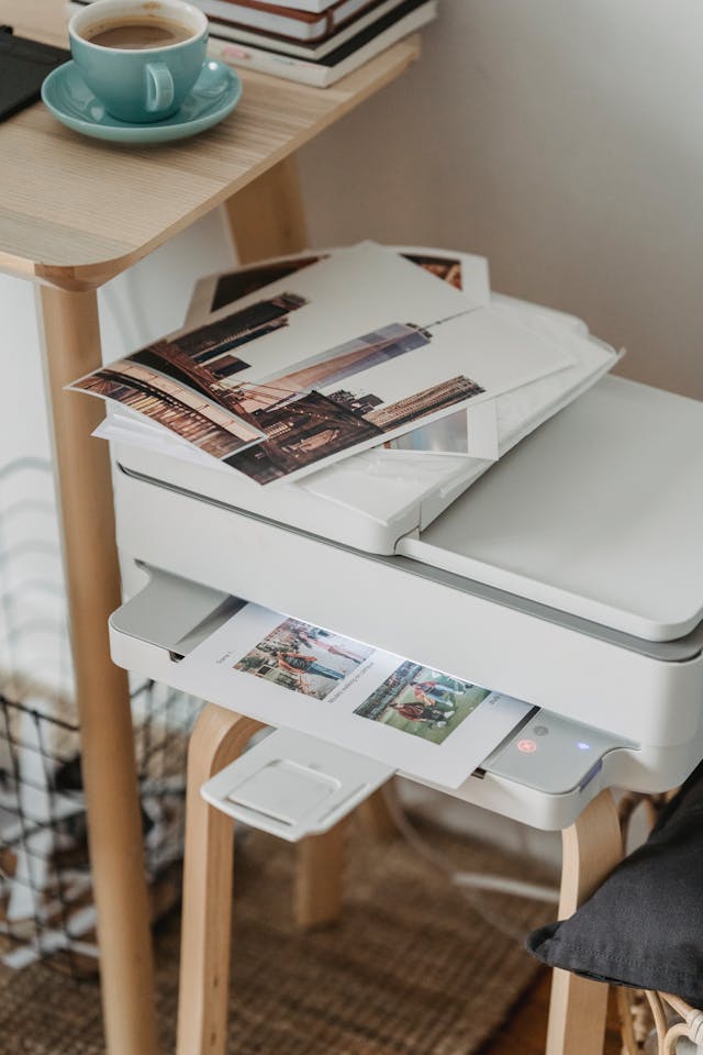 An image of a group of photos placed on top of a white printer. 
