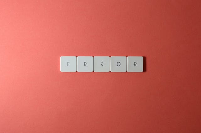 A close-up of keyboard buttons against a red background. The buttons spell out the word ‘Error.’