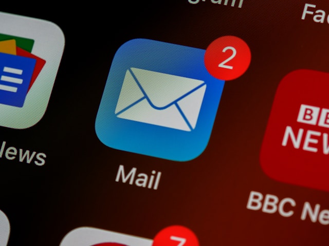 A close-up of the “Mail” app icon that as two red notifications on top of it. 