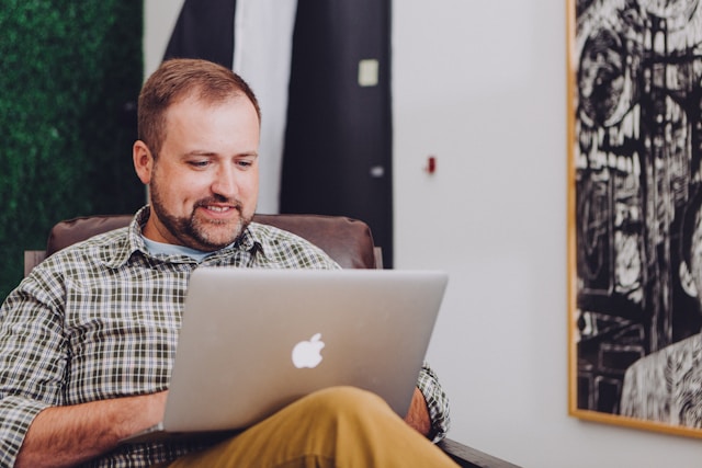 Stock image of a man using a laptop inside, representing the process of designing ecommerce websites for online shopping.