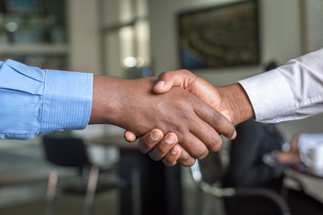 A close-up of two people shaking hands in an office. 