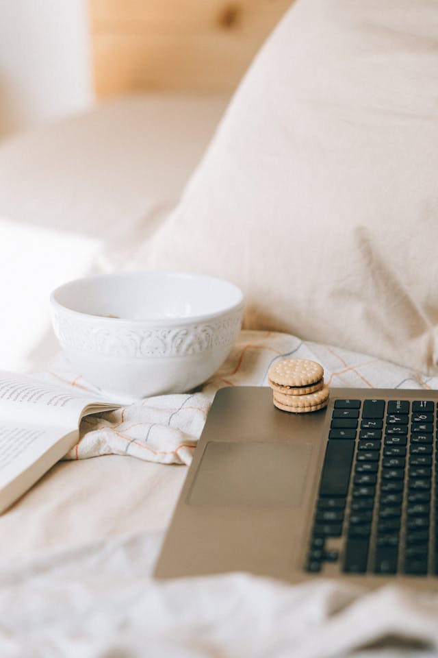 A couple of small, round cookies sit on top of a gray laptop. 
