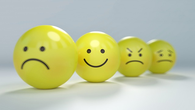 Four yellow spheres sit in a row, each with different emotional expressions on their surfaces. 
