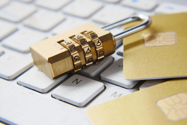 A close-up of a golden padlock on top of a laptop’s keyboard. 
