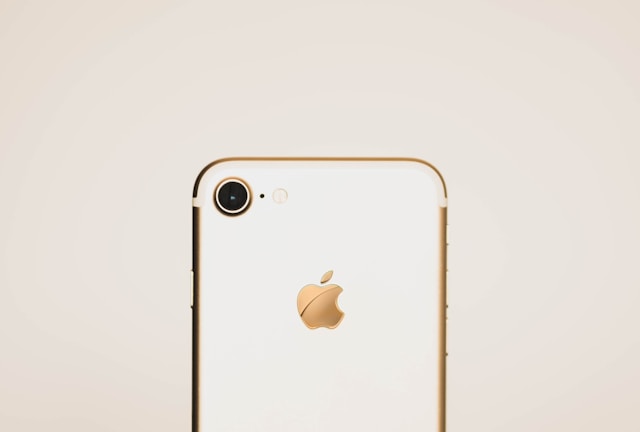 A white iPhone with a gold Apple logo on the back.