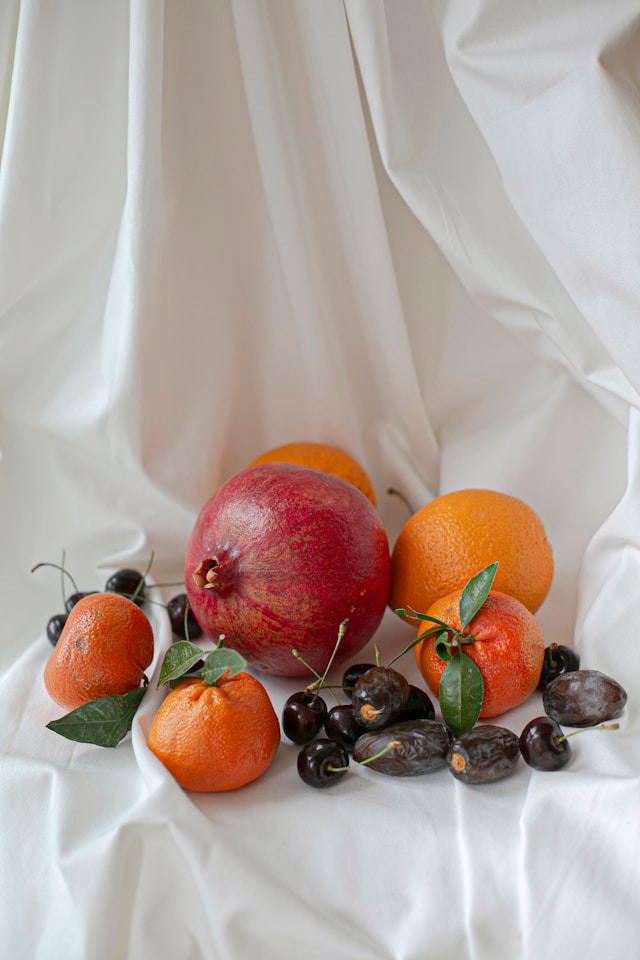 A realistic still-life image of fruit on a white sheet.