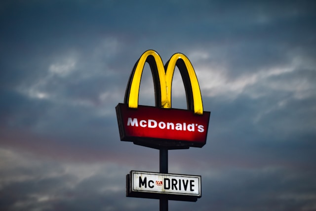A close-up of the McDonald’s sign with a cloudy sky in the background.