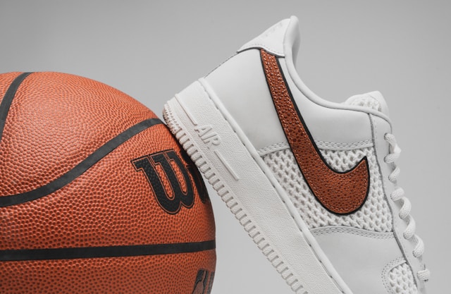 A close-up of a Nike Air trainer leaning on a basketball.