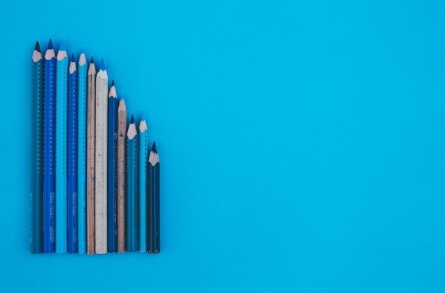 A row of differently sized brown and blue pencils representing the importance of sizing within a visual hierarchy. 