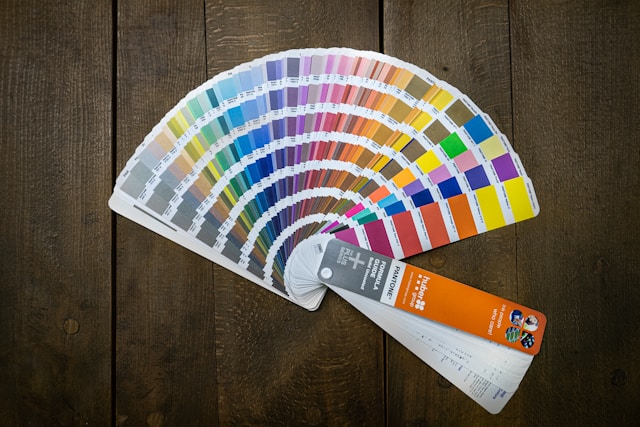 A Pantone color chart laid out on a wooden table.