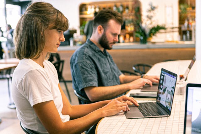 A person at a laptop using Canva.