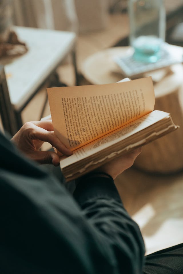 A close-up of a person turning the page of a book. 