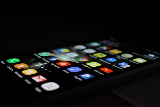 A black iPhone displaying many apps on its screen.