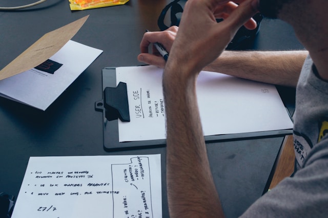 Stock image of a team reviewing user research documents and notes on a desk, showing the differences between design and UX.