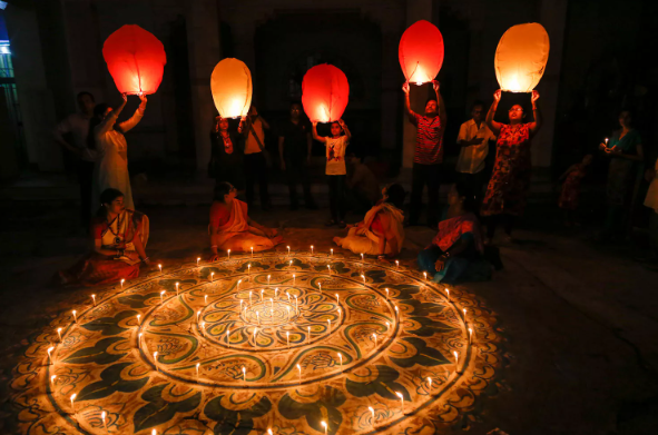 A Page Flows screenshot from People.com of some people holding up lanterns while celebrating the Festival of Lights (Diwali).