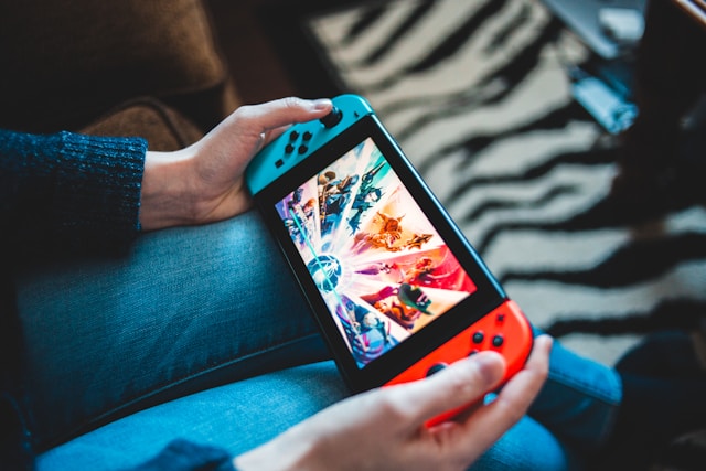 A close-up of a person playing a colorful game on their Nintendo Switch. 
