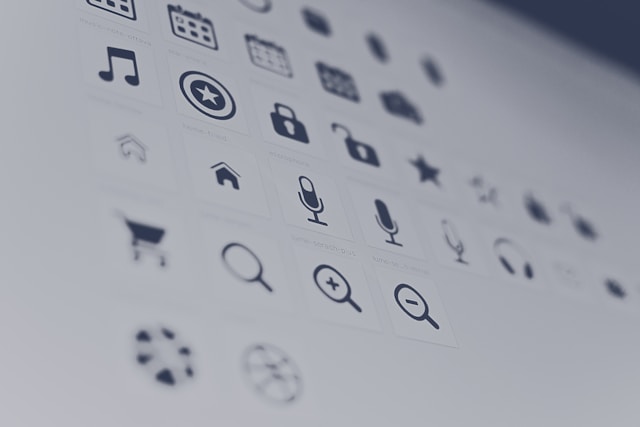 A close-up of a group of different, achromatic icons representing the icons UI designers create. 
