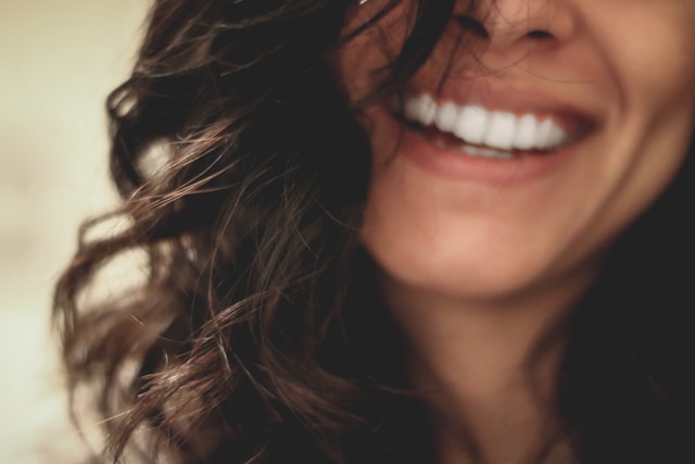 A close-up of a woman smiling, which represents joy. 
