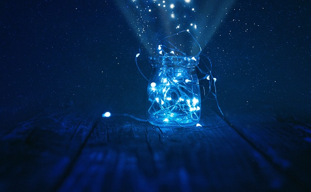 A close-up of string lights in a jar emanating a soft blue glow.