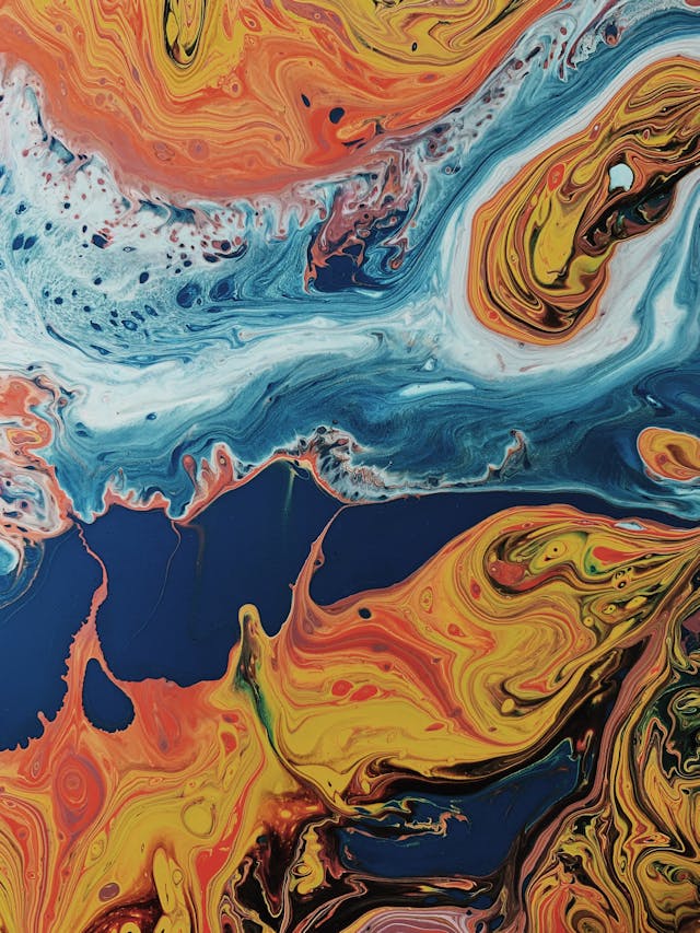 A close-up of swirls of orange, white, and blue paint representing a random color combination. 
