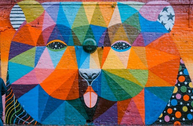 A close-up of bright, bold graffiti that comprises a medley of colors and geometric shapes. 


