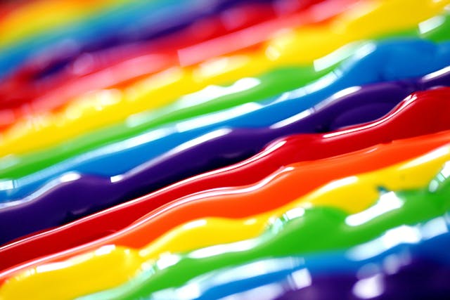 A close-up of paint that contains the colors of the rainbow. 
