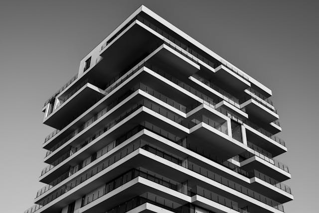 A grayscale photo of a building with an unconventional shape and structure.