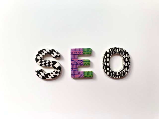 The word “SEO” written with different colored letters on a white surface.
