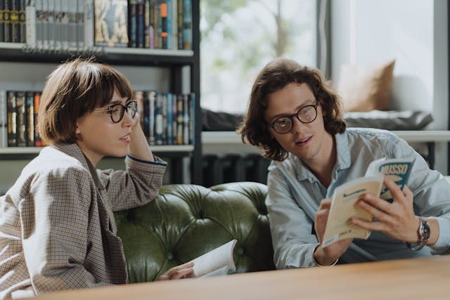 Two people looking at a book together.
