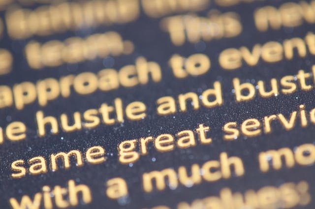 A close-up of a group of yellow-tinted words against a black background. 