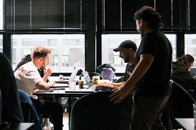 A team working in an office space with laptops on the table.
