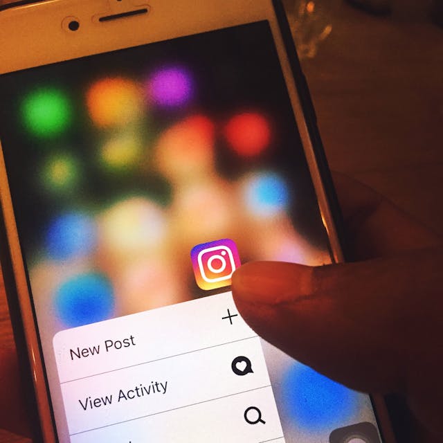 A close-up of a person interacting with the Instagram app on their mobile phone. 

