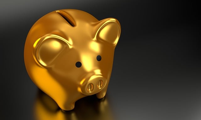 A close-up of a golden piggy bank against a black background.