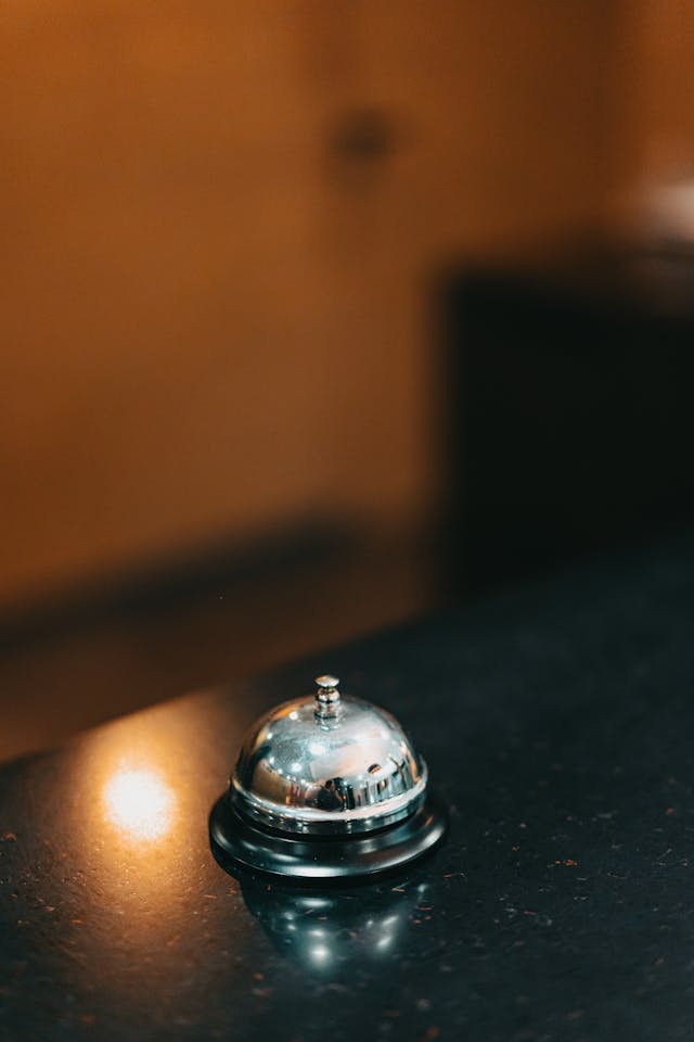 A shiny metal call bell on a reception desk.
